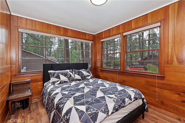 bedroom featuring wood-type flooring and wooden walls