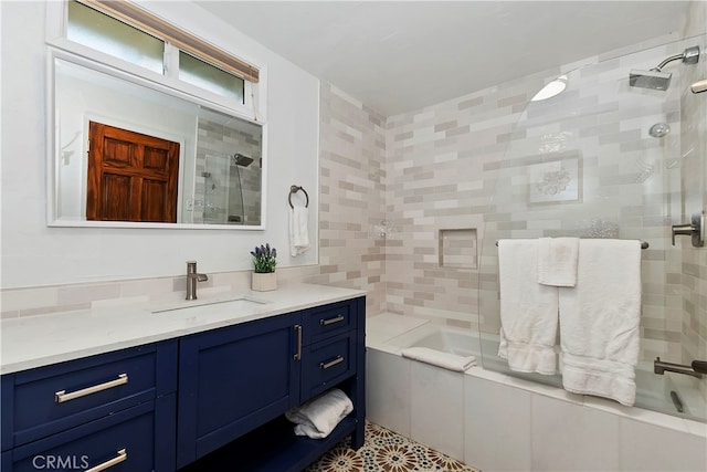 bathroom with vanity, tiled shower / bath combo, and tile walls