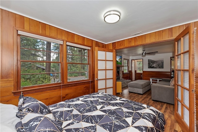 bedroom with wooden walls and dark hardwood / wood-style floors