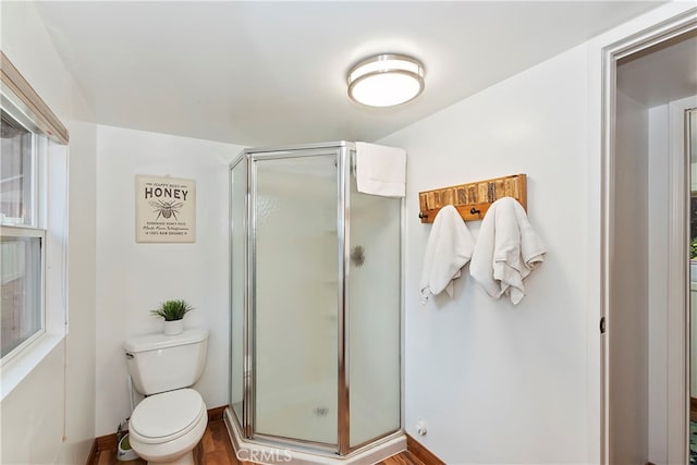 bathroom featuring toilet, hardwood / wood-style flooring, and walk in shower