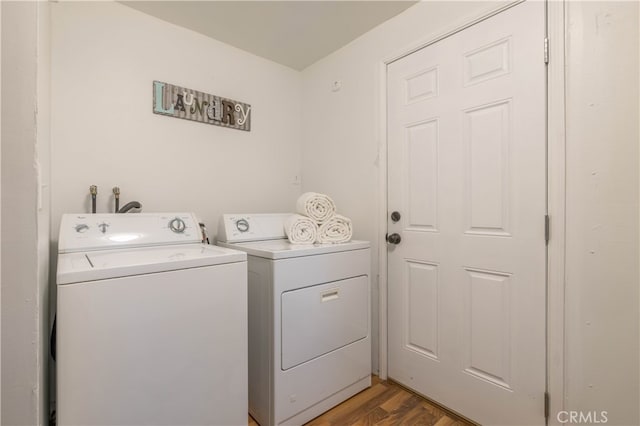 washroom with washer and clothes dryer and wood-type flooring