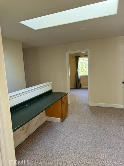 hall featuring light carpet and a skylight