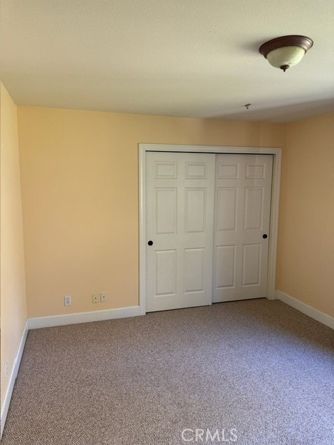 unfurnished bedroom with carpet and a closet