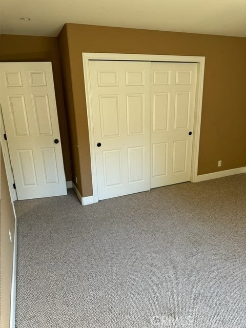 unfurnished bedroom with carpet flooring and a closet