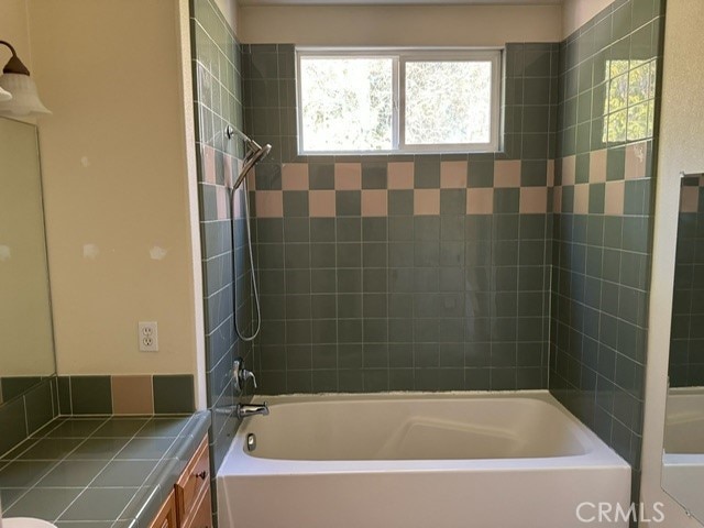 full bathroom with vanity, tiled shower / bath combo, and toilet