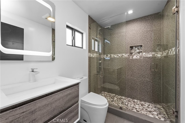 bathroom with vanity, a shower with shower door, toilet, and tile patterned flooring