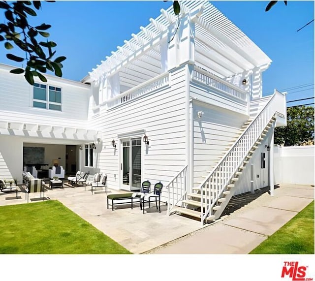 rear view of property featuring a patio area, an outdoor living space, a lawn, and a pergola