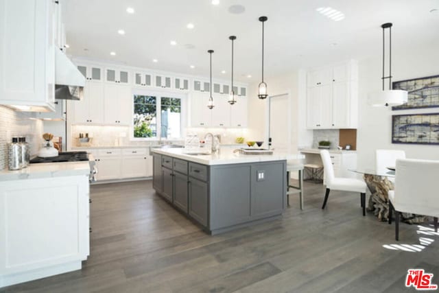 kitchen with sink, white cabinetry, pendant lighting, gray cabinets, and a kitchen island with sink