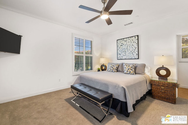 carpeted bedroom with ceiling fan and ornamental molding