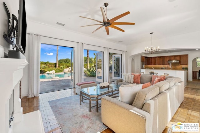 living room featuring light tile patterned floors and ceiling fan with notable chandelier