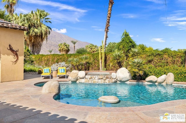 view of pool with a mountain view and a patio