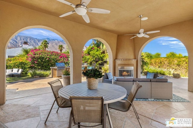 view of patio / terrace with a mountain view, grilling area, a fireplace, and ceiling fan