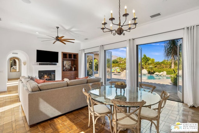 dining room featuring ornamental molding, parquet floors, ceiling fan with notable chandelier, and built in features