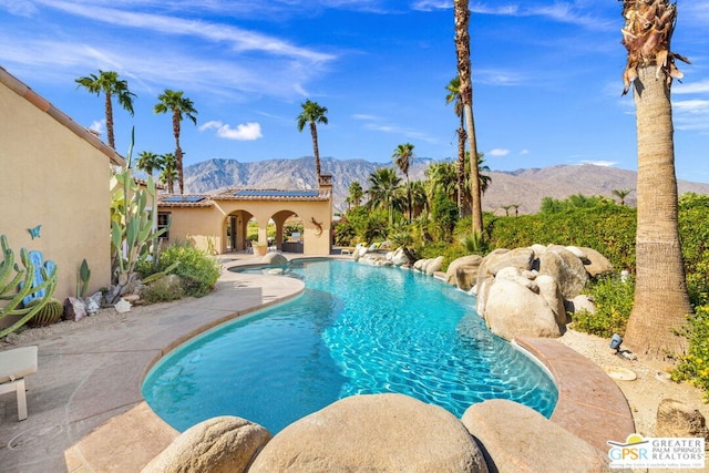 view of swimming pool featuring a mountain view and a patio