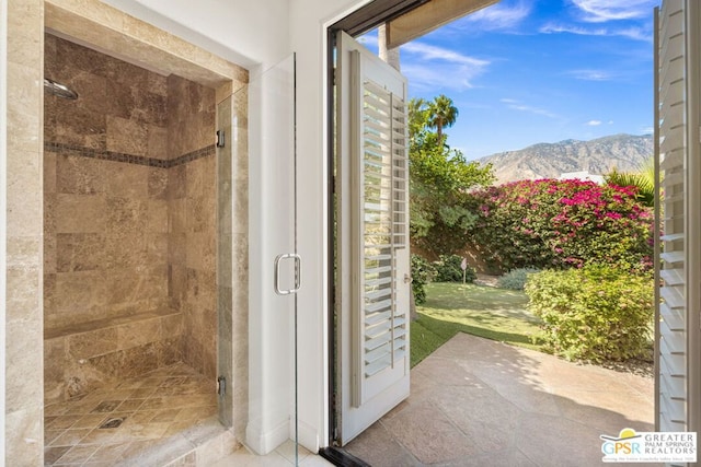 bathroom featuring a shower with door and a mountain view