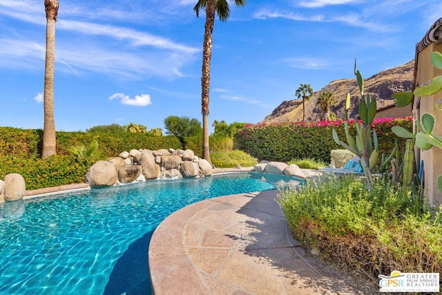 view of swimming pool with a mountain view and pool water feature