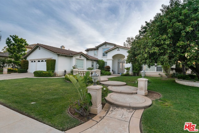 mediterranean / spanish-style house with a front yard and a garage