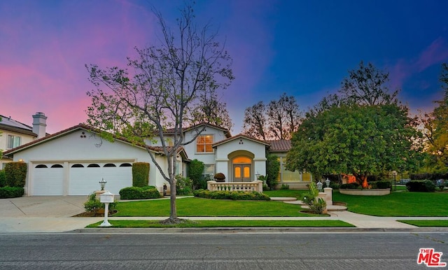 view of front facade with a lawn, french doors, and a garage