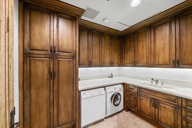 laundry area featuring sink, washing machine and clothes dryer, light tile patterned floors, and cabinets