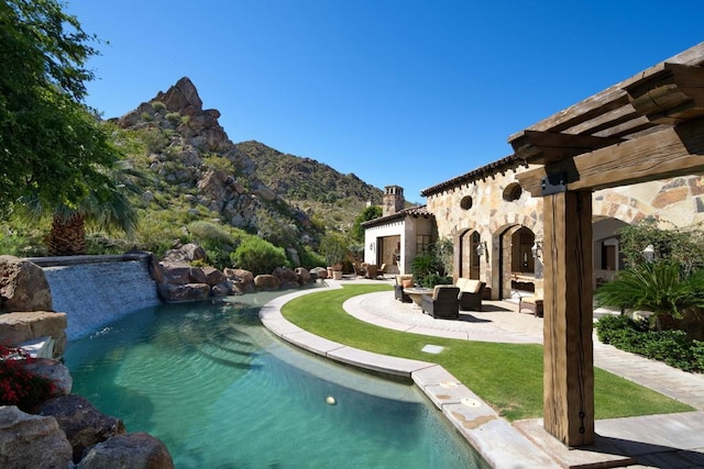 view of pool with a mountain view, a patio area, and a lawn