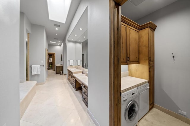 laundry room featuring washer / dryer, light tile patterned floors, and a skylight