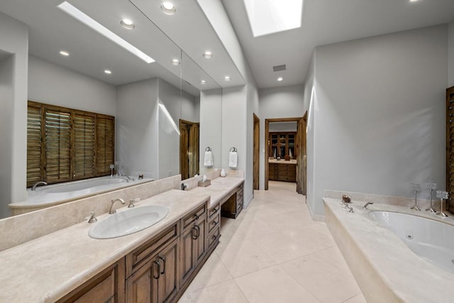 bathroom with vanity, a tub to relax in, a skylight, and tile patterned flooring