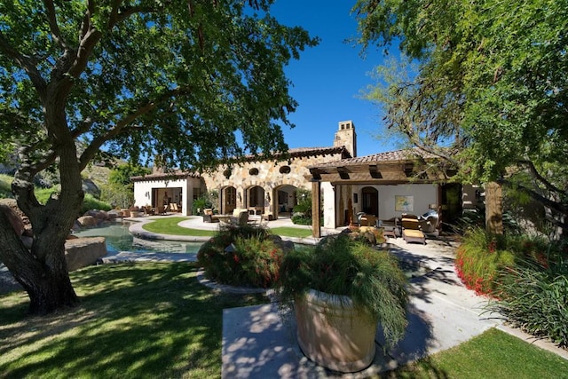 back of house with a patio and a lawn