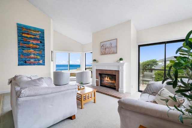 living room with carpet, a water view, lofted ceiling, and a brick fireplace