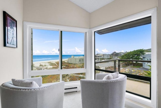 sunroom featuring plenty of natural light, a water view, a beach view, and a baseboard radiator