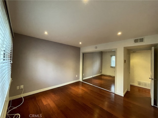 unfurnished bedroom featuring a closet and hardwood / wood-style floors