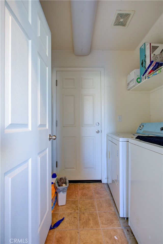 laundry area featuring light tile patterned flooring and washing machine and dryer