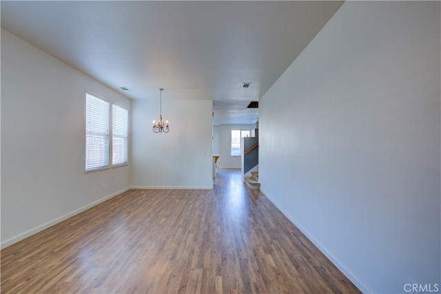 unfurnished room featuring dark wood-type flooring and a chandelier