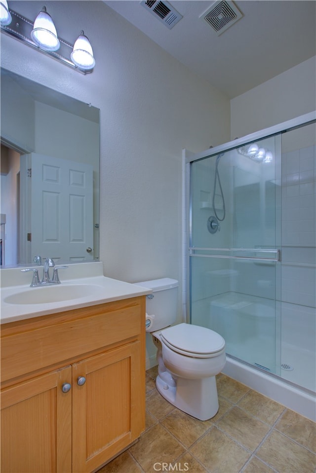 bathroom with vanity, toilet, walk in shower, and tile patterned flooring