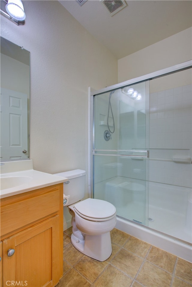 bathroom with vanity, toilet, tile patterned flooring, and an enclosed shower