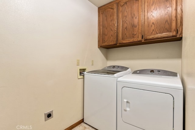 clothes washing area with independent washer and dryer and cabinets