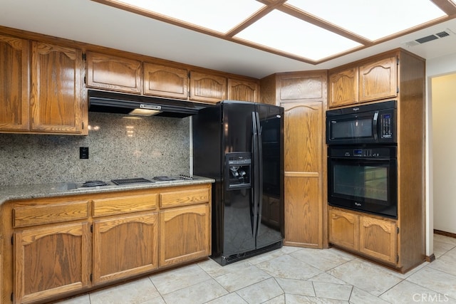 kitchen with tasteful backsplash, black appliances, and light tile patterned floors