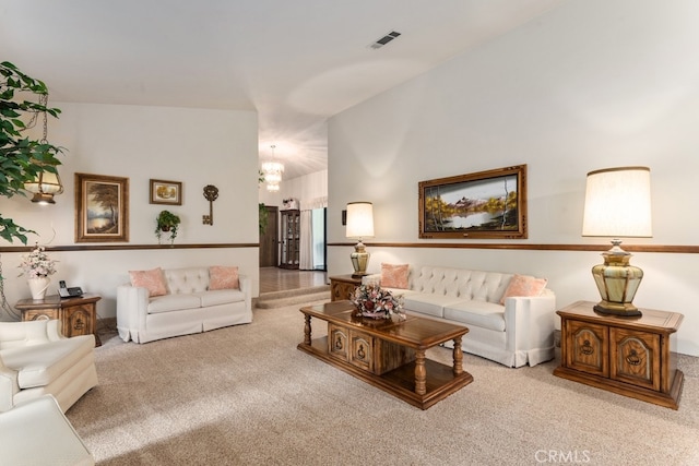 living room with light carpet, an inviting chandelier, and high vaulted ceiling