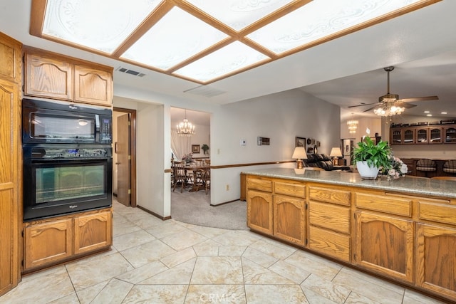 kitchen featuring light carpet, black appliances, and ceiling fan with notable chandelier