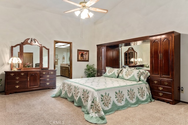 bedroom featuring light carpet, ensuite bath, high vaulted ceiling, and ceiling fan