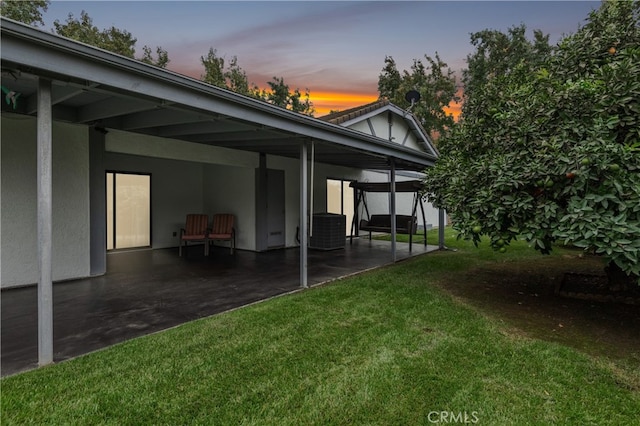 yard at dusk featuring a patio area and central AC unit