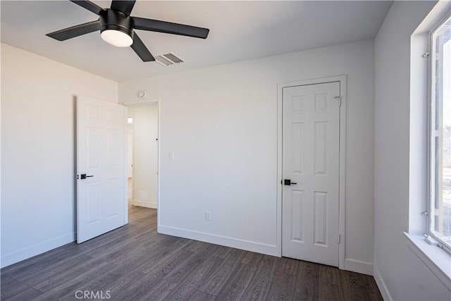 unfurnished bedroom featuring ceiling fan and dark hardwood / wood-style floors