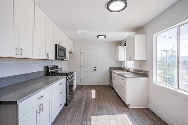 kitchen with white cabinets, a healthy amount of sunlight, dark hardwood / wood-style floors, and appliances with stainless steel finishes