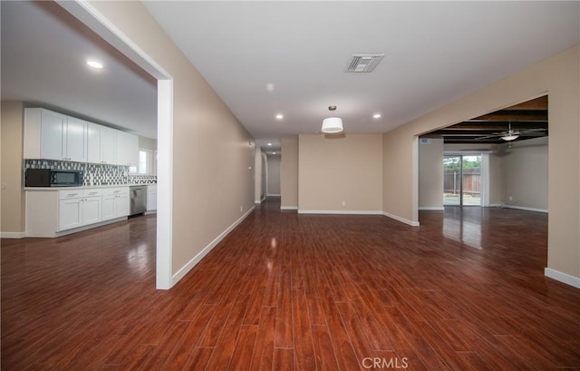 empty room with ceiling fan and dark hardwood / wood-style flooring