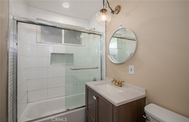 full bathroom featuring toilet, enclosed tub / shower combo, and vanity