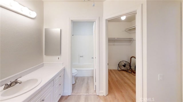 full bathroom featuring vanity, hardwood / wood-style floors, independent shower and bath, and toilet