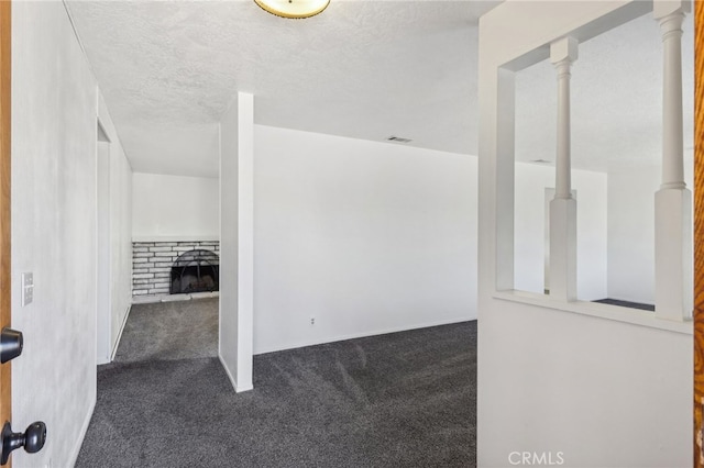 interior space with dark colored carpet and a textured ceiling