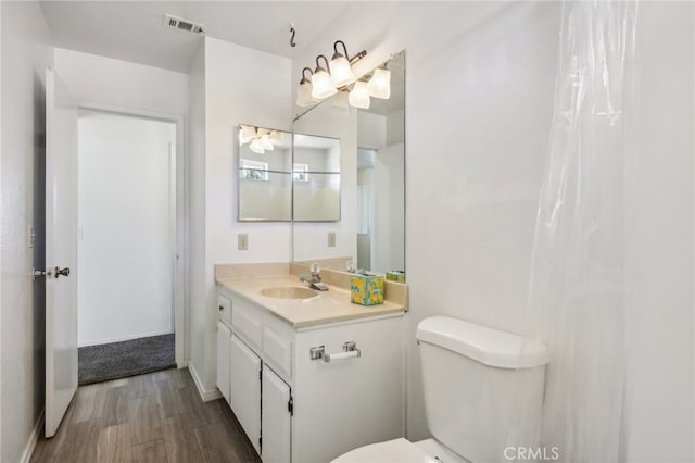 bathroom with vanity, toilet, and hardwood / wood-style floors