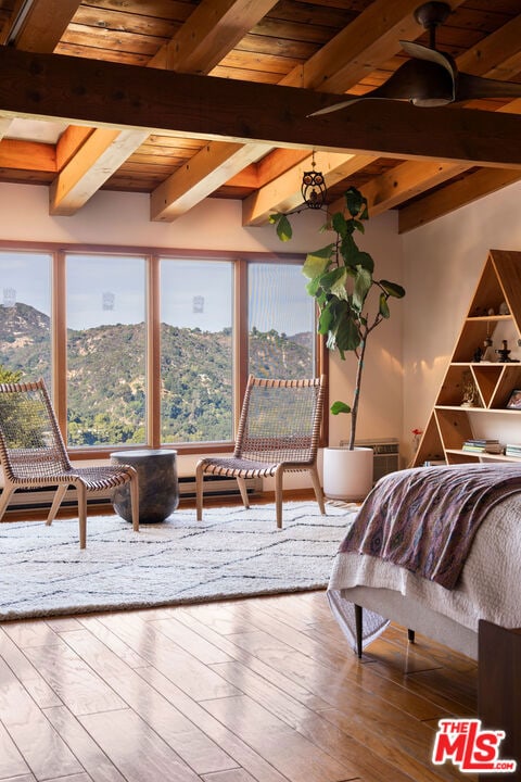 bedroom with beam ceiling, wood-type flooring, wood ceiling, and a mountain view