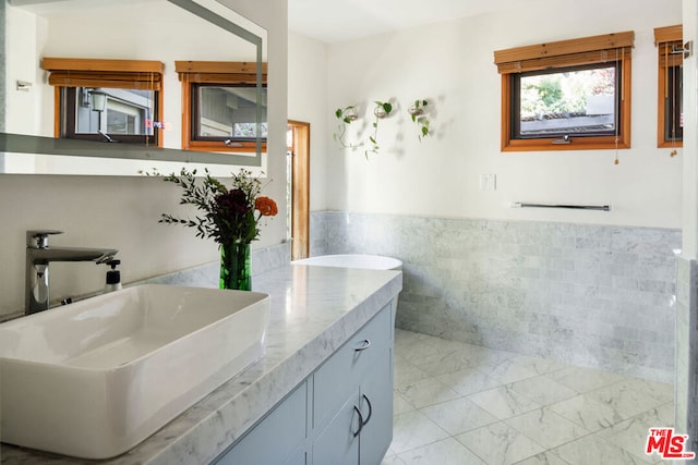 bathroom with tile walls and vanity