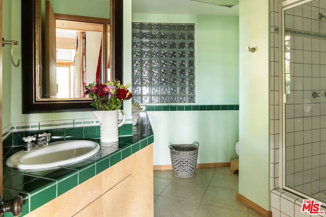 bathroom with sink, tile patterned floors, toilet, and an enclosed shower